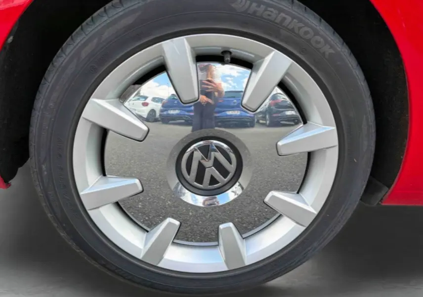 Gros plan sur la jante 18 pouces Disc argentée d’une Volkswagen Coccinelle rouge Tornade, avec pneu Hankook visible.