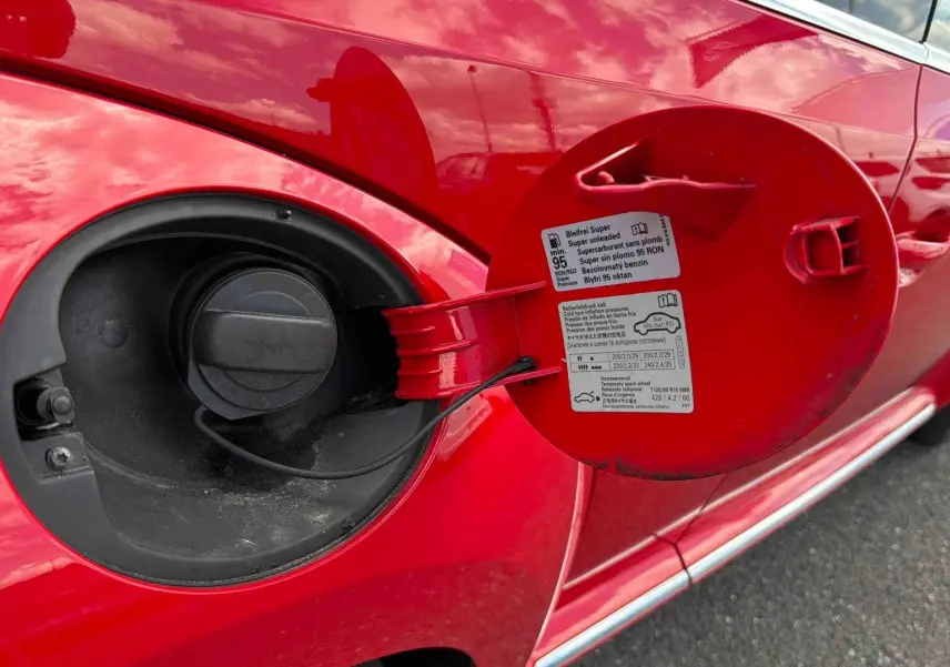 Vue rapprochée du bouchon de réservoir ouvert sur le côté gauche d’une Volkswagen Coccinelle rouge Tornade.