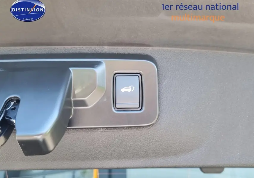 Bouton d'ouverture électrique du coffre sur la garniture intérieure du hayon d'une Renault Rafale noir étoile.