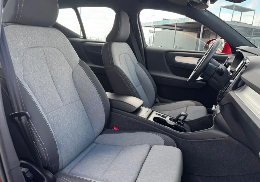 Intérieur du Volvo XC40 B3 2024 vu côté droit, sièges tissu gris clair avec console centrale noire.