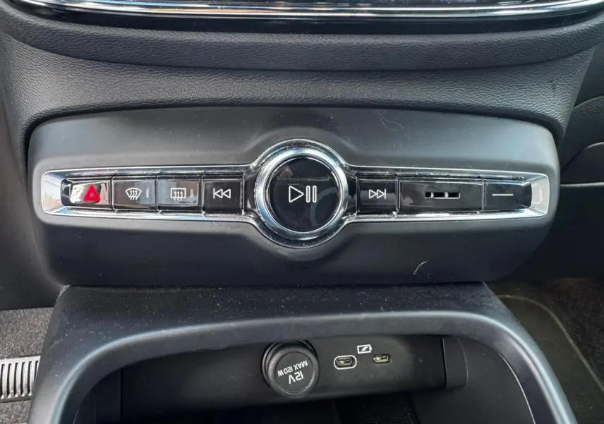 Gros plan sur la console centrale noire du Volvo XC40 2024 montrant les commandes multimédia et ports USB.
