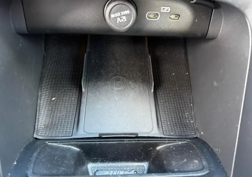 Gros plan sur la console centrale du Volvo XC40 2024 montrant les ports USB et la prise 12V noire.