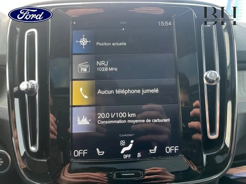 Écran tactile central du tableau de bord du Volvo XC40 noir, affichant navigation et consommation moyenne