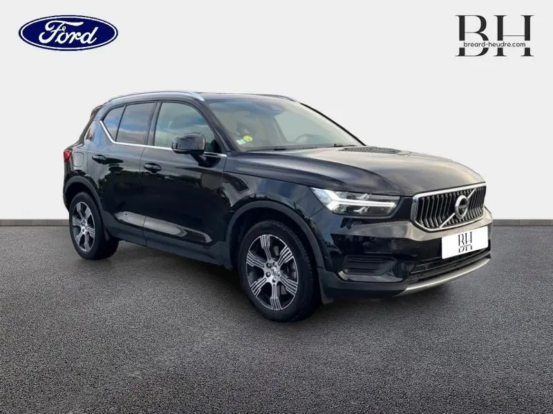 Volvo XC40 noir en 3/4 avant droit, mettant en valeur sa calandre distinctive et ses jantes alliage.
