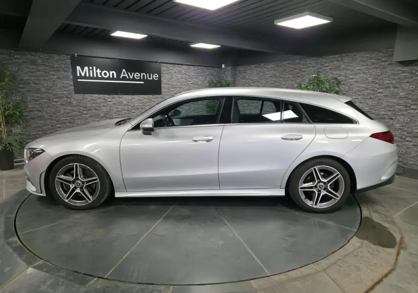 Vue de profil côté gauche d'une Mercedes CLA Shooting Brake gris métallisé avec jantes AMG cinq branches.
