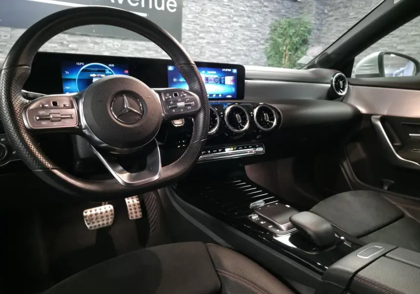 Vue intérieure avant droite de la Mercedes CLA Shooting Brake 200 AMG Line 2020 avec volant sport et écran digital large.