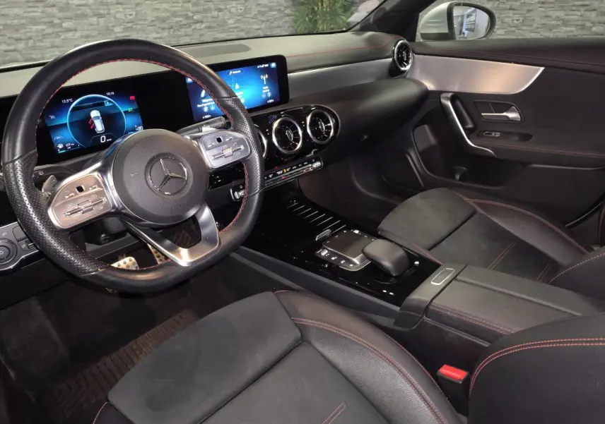 Vue intérieure côté conducteur de la Mercedes CLA Shooting Brake AMG Line 2020 avec sellerie noire et surpiqûres rouges.