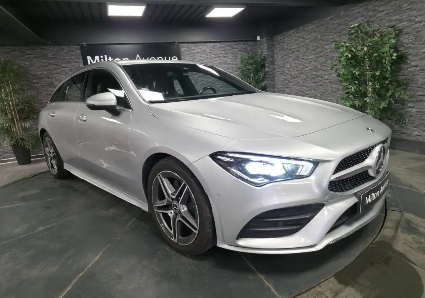Vue 3/4 avant droite d'une Mercedes CLA Shooting Brake gris métallisé avec calandre diamant et jantes AMG cinq branches.