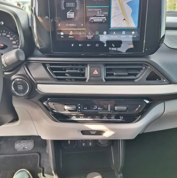Vue intérieure centrée sur la console centrale de la Suzuki Swift 2025, écran tactile avec navigation et commandes climatisation.