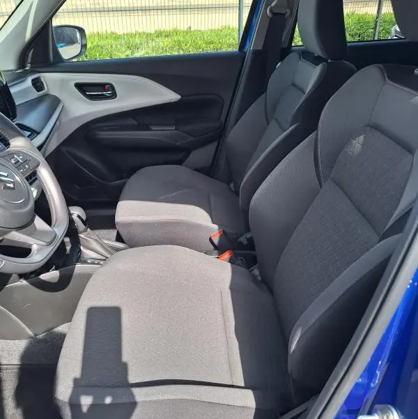 Vue intérieure côté conducteur de la Suzuki Swift 2025 bleu, sièges tissu gris et volant multifonction.