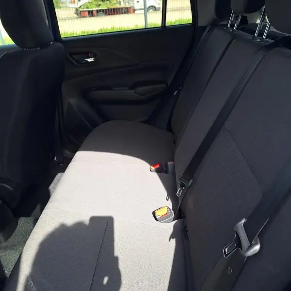 Vue intérieure de la banquette arrière noire de la Suzuki Swift 2025, avec ceintures et appuis-tête visibles.