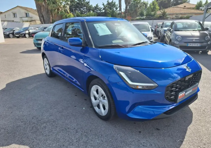 Suzuki Swift 1.2 Hybrid bleu vue 3/4 avant droit, avec calandre noire et jantes alliage 16 pouces.