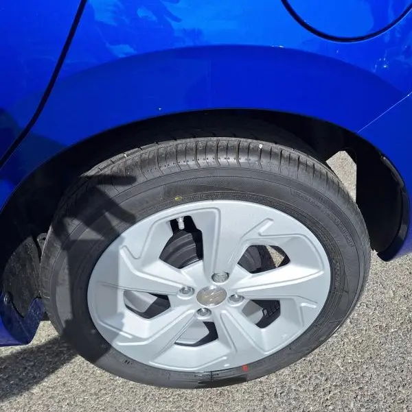 Gros plan sur la roue arrière droite d'une Suzuki Swift 2025 bleu avec jante alliage 16 pouces.