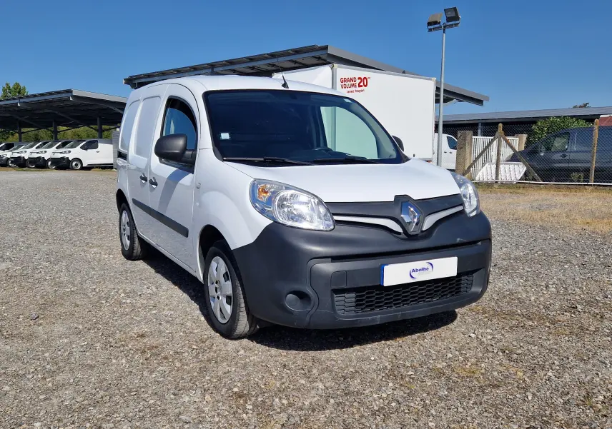 Vue 3/4 avant d’un Renault Kangoo blanc 2021 avec pare-chocs noir mat et calandre marquée du logo Renault.