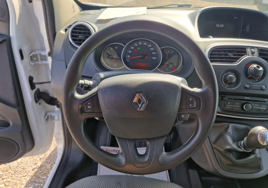 Vue intérieure centrée sur le volant noir du Renault Kangoo blanc 2021 avec tableau de bord et levier de vitesses manuel.