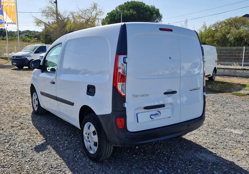 Renault Kangoo blanc vue 3/4 arrière droit, fourgonnette utilitaire avec hayon fermé sur parking extérieur.
