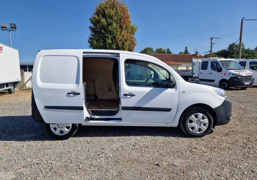 Vue de profil droit d’un Renault Kangoo blanc 2021 avec porte coulissante ouverte, montrant l’intérieur utilitaire vide.