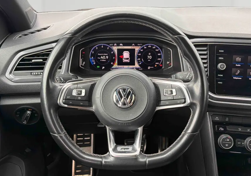Vue intérieure centrée sur le volant cuir multifonctions R-Line et le tableau de bord digital du Volkswagen T-Roc 2020.