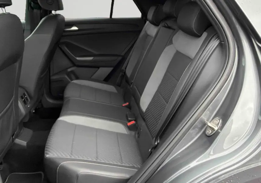 Vue côté droit de l'intérieur arrière du Volkswagen T-Roc gris Indium, sièges en similicuir et tissu gris foncé.