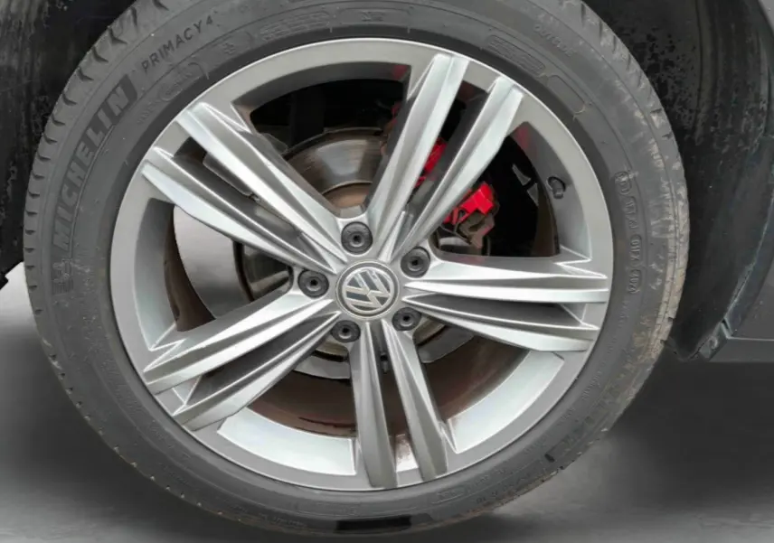 Gros plan sur la jante alliage 18 pouces Nevada gris indium métal du Volkswagen T-Roc avec étrier de frein rouge visible.