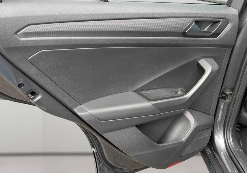 Vue rapprochée de la porte arrière gauche gris Indium métal du Volkswagen T-Roc 2020 avec accoudoir et commande de vitre.
