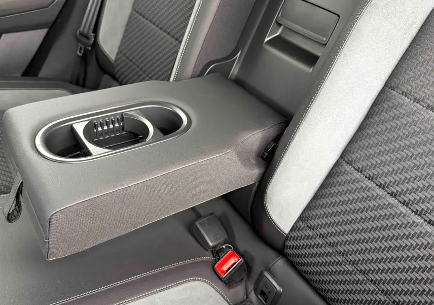 Gros plan sur l'accoudoir central arrière en similicuir gris avec porte-gobelets du Volkswagen T-Roc 2020.