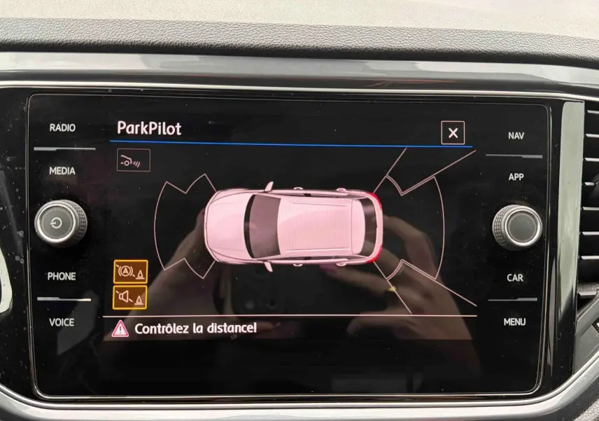 Écran tactile intérieur affichant l'aide au stationnement ParkPilot d'un Volkswagen T-Roc gris Indium Metal.