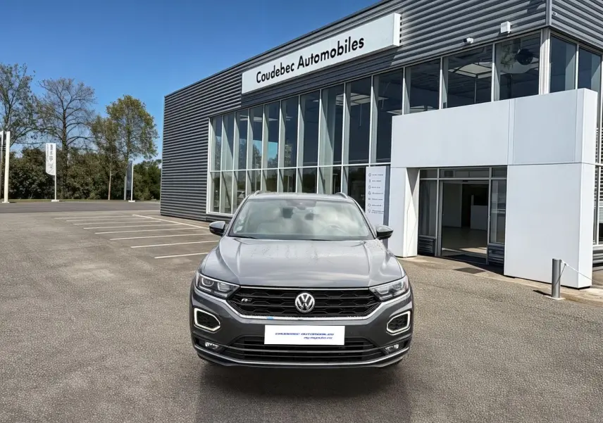 Volkswagen T-Roc gris Indium Metal vue de face, avec calandre R-Line et éclairage LED distinctif.