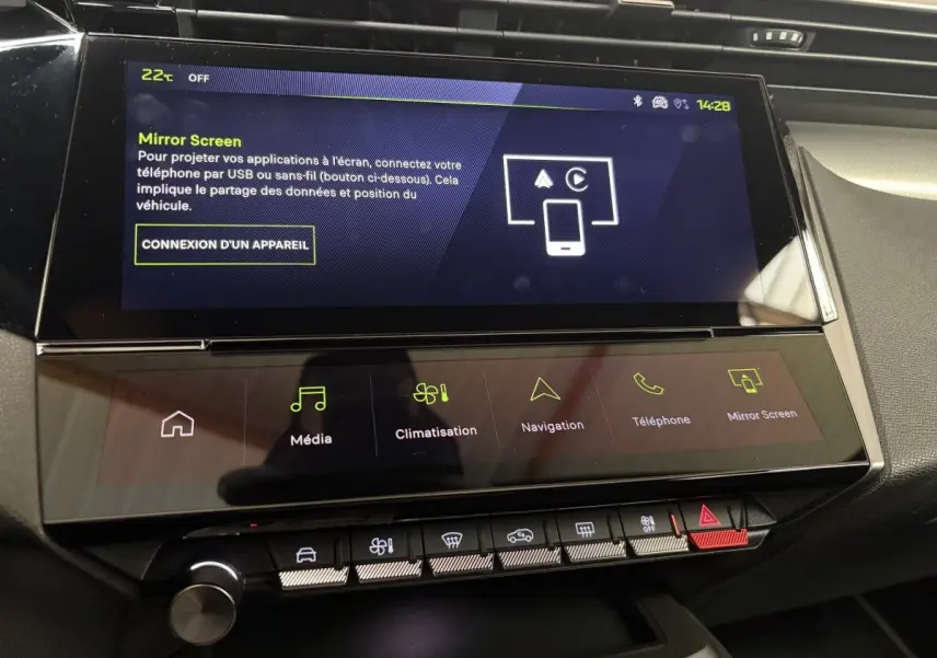 Écran tactile central du tableau de bord de la Peugeot 308 Hybrid 2025 avec interface multimédia et climatisation.