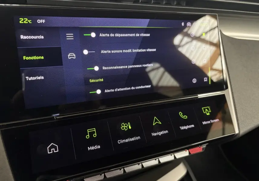 Écran tactile central de la Peugeot 308 Hybrid 2025 affichant les réglages d'alerte et navigation, vue intérieure frontale.