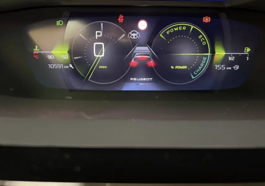 Tableau de bord numérique de la Peugeot 308 hybride, affichant vitesse, autonomie et indicateurs de puissance.