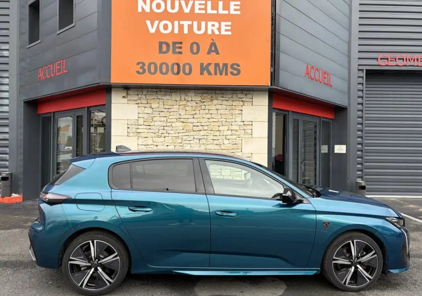 Profil côté gauche d'une Peugeot 308 hybride 2025 bleu métallisé, avec jantes alliage et vitres teintées.