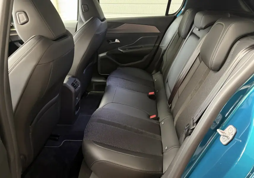 Vue intérieure côté droit des sièges arrière en cuir noir de la Peugeot 308 1.2 Hybrid 145 GT bleu 2025.