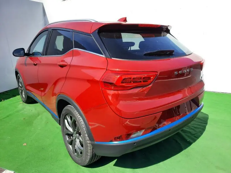 Vue 3/4 arrière droite du SUV électrique SERES 3 Luxury rouge carmin avec toit panoramique et antenne requin.