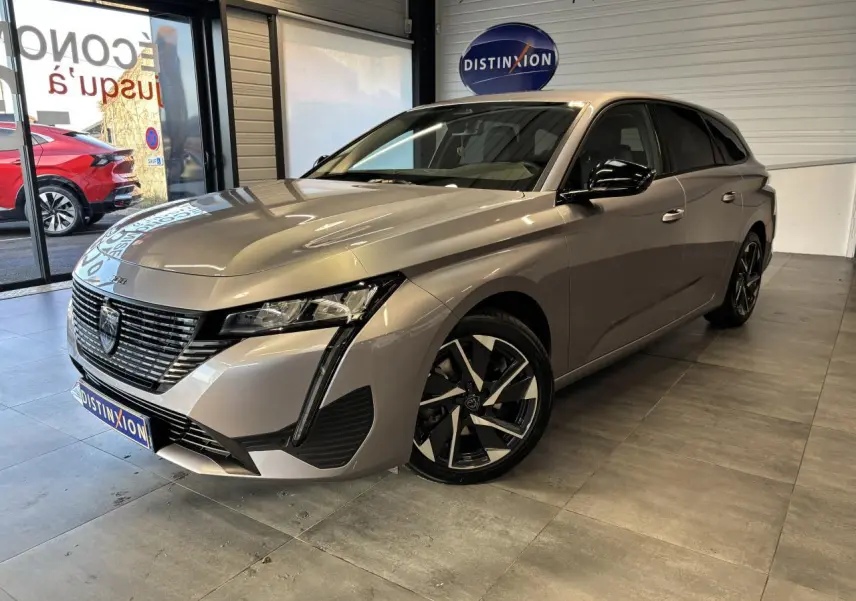 Peugeot 308 SW gris clair Metal Artense vue 3/4 avant droit, avec calandre noire et jantes alliage 17 pouces.