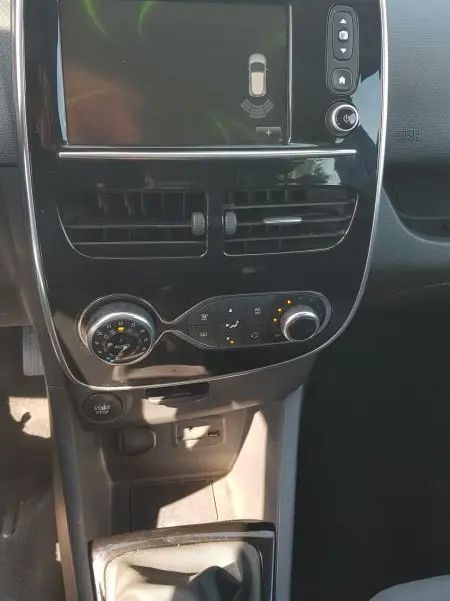 Vue rapprochée du tableau de bord et console centrale noire de la Renault Clio IV dCi 90 eco2 Intens avec écran tactile et levier de vitesse manuel.