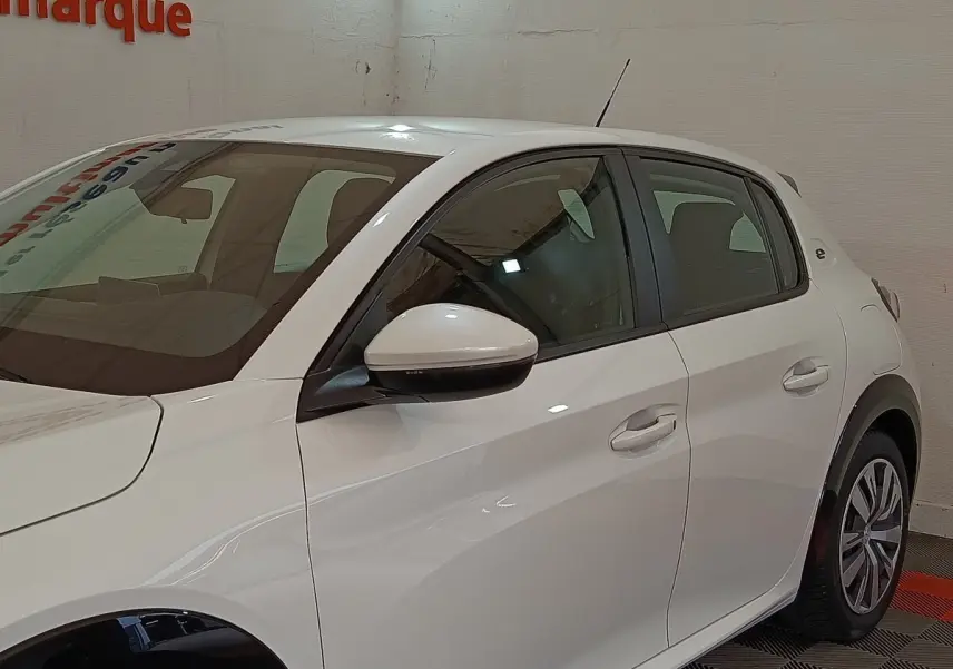 Vue côté gauche d'une Peugeot 208 électrique Active Business blanche, avec rétroviseur et poignées assortis.