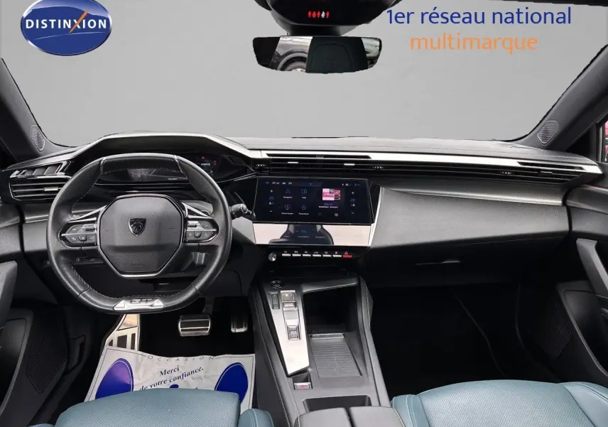 Vue intérieure frontale du Peugeot 308 SW hybride 2022, avec tableau de bord moderne noir et écran tactile central.