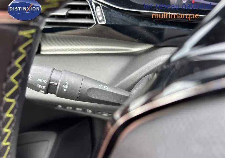 Gros plan sur la commande des clignotants et feux, intérieur noir du Peugeot 308 SW hybride blanc nacré 2022.