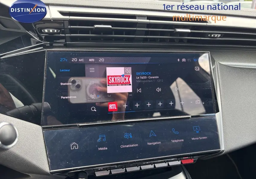 Écran tactile central du tableau de bord de la Peugeot 308 SW hybride, affichant la radio Skyrock en intérieur noir et gris.