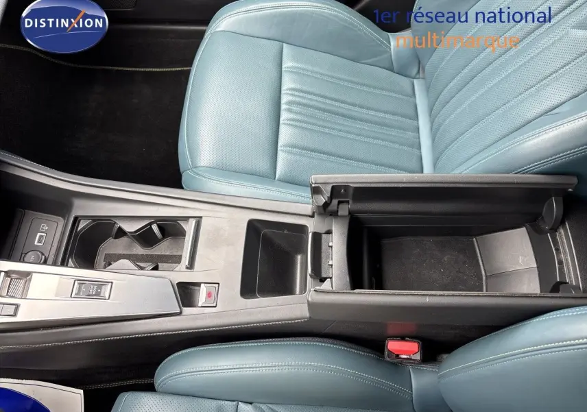 Vue plongeante sur l'intérieur de la Peugeot 308 SW hybride, montrant les sièges en cuir bleu et la console centrale ouverte.