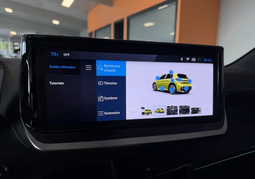 Écran tactile intérieur montrant un menu d’aide avec une illustration d’une Peugeot 208 jaune vue de trois quarts arrière.