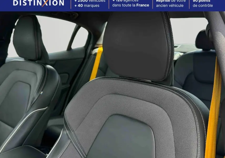 Gros plan sur les sièges avant en tissu et cuir anthracite avec ceintures de sécurité jaunes dans l'habitacle d'une Volvo S60.