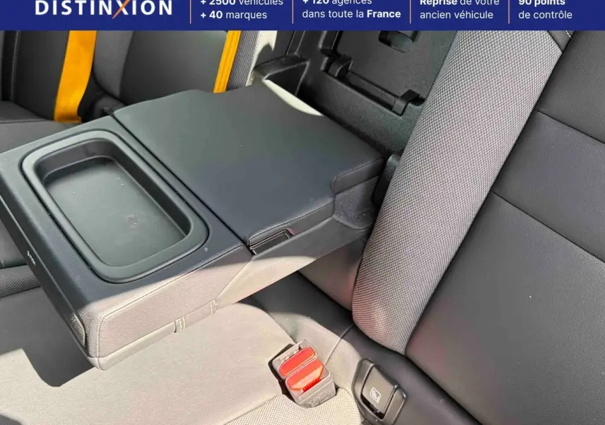 Détail de l'accoudoir central arrière noir et sellerie tissu/cuir anthracite avec ceintures de sécurité jaunes sur Volvo S60 blanche.