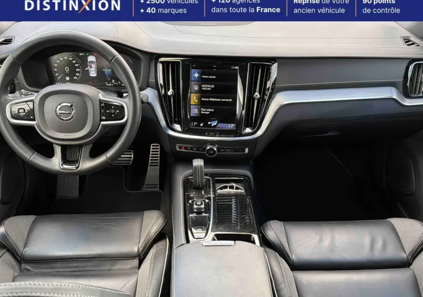 Vue intérieure avant de la Volvo S60 T8 2021, tableau de bord noir avec écran tactile central et volant cuir multifonctions.