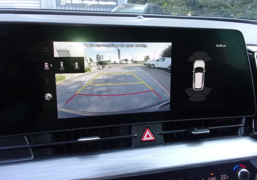 Écran tactile 12,3'' du Kia Sportage gris perle 2025 montrant la caméra de recul avec guidage et vue 360° intérieure.