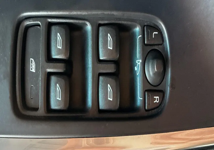 Panneau de commandes des vitres et rétroviseurs côté conducteur d'un Volvo XC60 gris 2016, vue rapprochée.