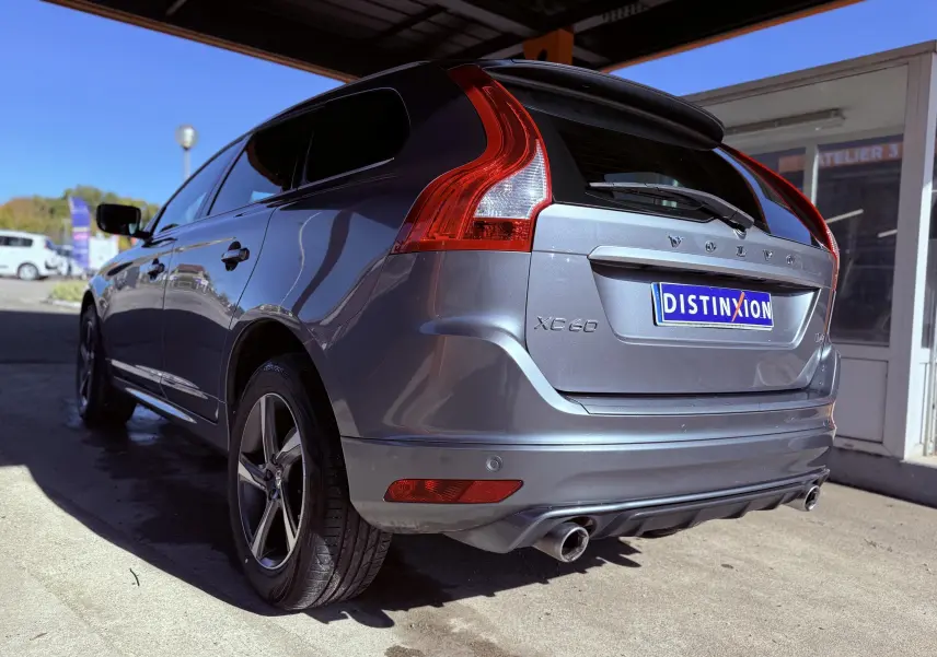 Vue 3/4 arrière droite d'un Volvo XC60 gris 2016 avec feux arrière caractéristiques et double sortie d'échappement.