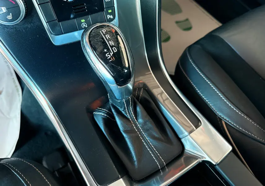 Le levier de vitesses automatique du Volvo XC60 D4 gris 2016 vu en gros plan depuis l'intérieur côté console centrale.
