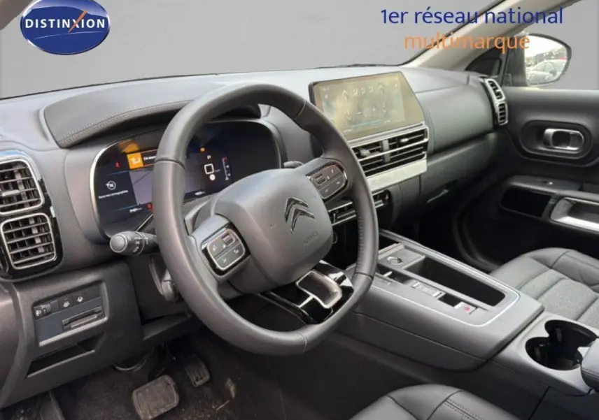 Intérieur du Citroën C5 Aircross Hybrid 2025 vu côté conducteur, tableau de bord moderne et volant multifonction noir.
